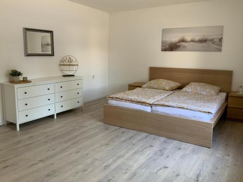 a bedroom with a bed and a dresser at Ferienhaus Undine in Oranienbaum-Wörlitz
