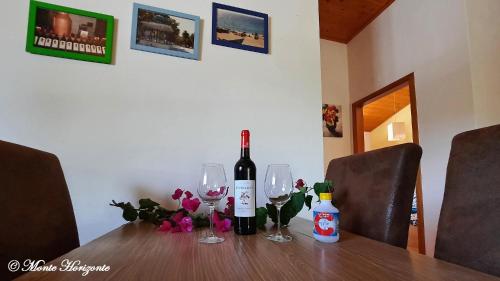 a bottle of wine and two glasses on a table at Monte Horizonte - Turismo Rural- Casas de Campo - Eco e Natureza - Adults Only in Santiago do Cacém