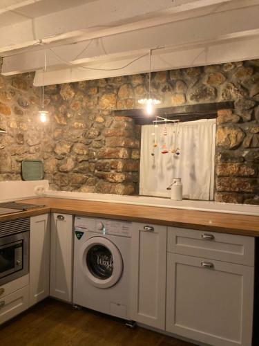a kitchen with a sink and a washing machine at Casa Utopia 1 in Grado
