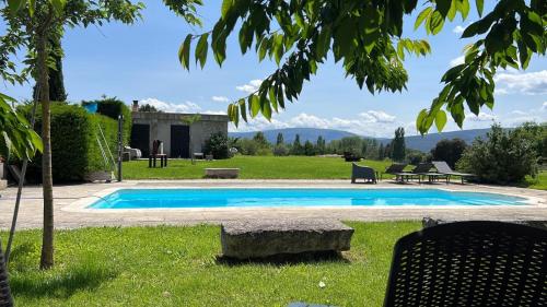 una piscina en un patio con montañas al fondo en casa rural de un artista en plena naturaleza piscina y parque de esculturas en villarcayo, en Villarcayo