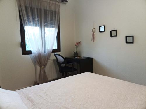 a bedroom with a bed and a desk and a window at Vaikouzis Houses in Samothráki