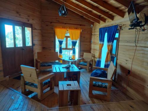 Habitación con mesa y sillas en una cabaña de madera en Cabaña Los Nogales, en Pátzcuaro