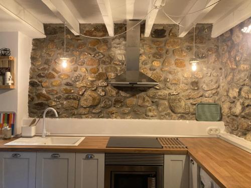 a kitchen with a stone wall with a stove at Casa Utopia 1 in Grado