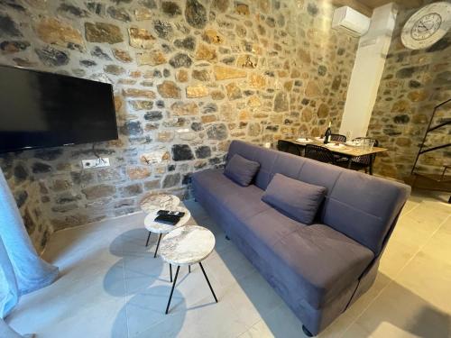 a living room with a couch and a stone wall at Casa Marel in Vlikhádha