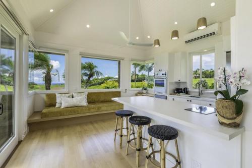 una cocina con una gran isla con taburetes y un sofá en Hale Lani home, en Kilauea