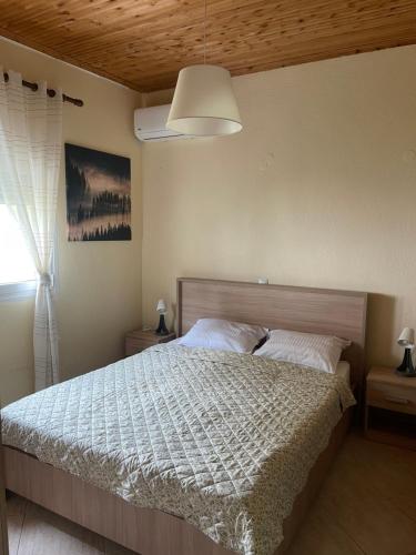 a bedroom with a bed with a white comforter at Villa Alexandros in Ammouliani