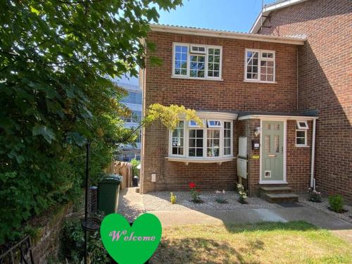 a brick house with a green heart in front of it at Redhill Town Centre 3 bed House near Gatwick Airport, easy commute to London in Redhill