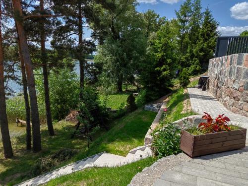 un jardín con árboles y césped y una escalera de piedra en Apartament nad jeziorem Sport i Rekreacja, en Ełk