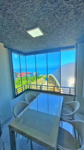 a table and chairs in a room with a view of the ocean at Osmanlı Suite Airport in Trabzon