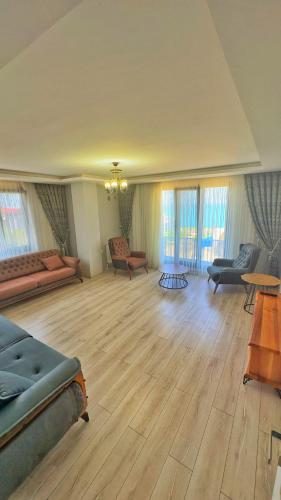 a large living room with wooden floors and furniture at Osmanlı Suite Airport in Trabzon