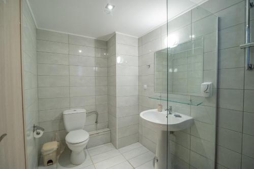 uma casa de banho com um WC, um lavatório e um chuveiro em Ocean Hotel Resort em Kastrosikia