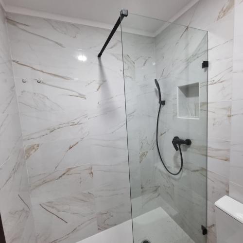 a bathroom with a shower with a glass door at Sun House Belem - Free Parking and View Tower in Lisbon