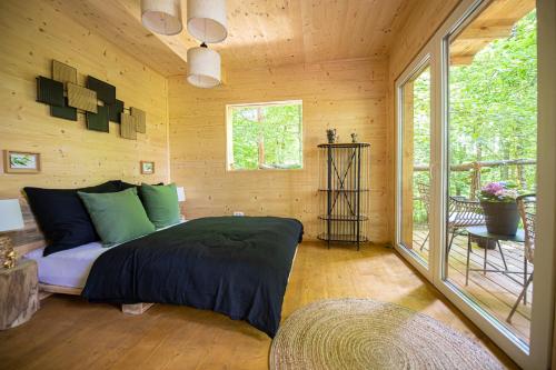 1 dormitorio con 1 cama en una cabaña de madera en Living Forest Resort en Moravske-Toplice