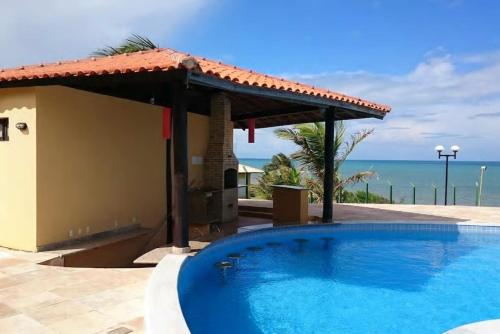 a swimming pool with a view of the ocean at Casa espetacular em condomínio pé-na-areia, PZ11 in Rio do Fogo
