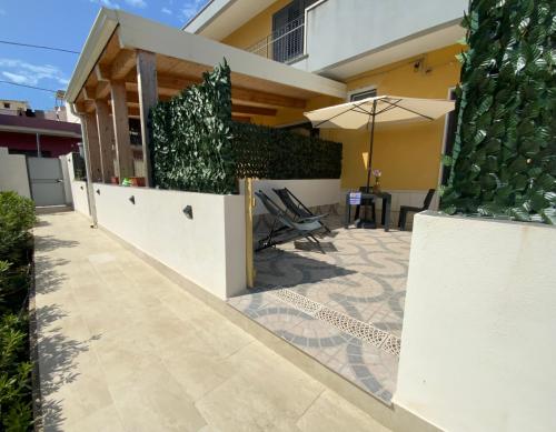 a patio of a house with an umbrella at “Bedda Mattri” dimora siciliana in Avola