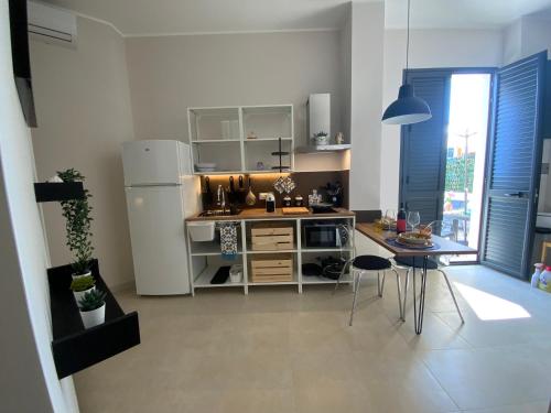 a kitchen with a refrigerator and a table with chairs at “Bedda Mattri” dimora siciliana in Avola