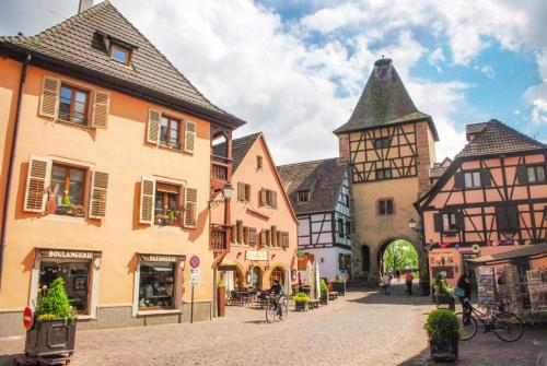 a street in a town with buildings and a tower at Le 6 : maison individuelle au cœur de l'Alsace in Turckheim