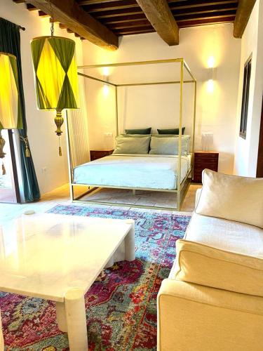 a bedroom with a bed and a table and a couch at Casa Fossatello in Nocera Umbra