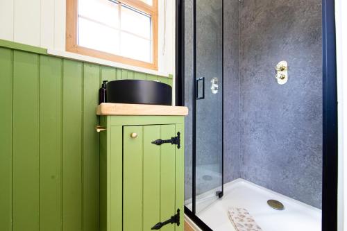 a bathroom with green cabinets and a shower at The Hut at Pengelli in Nelson