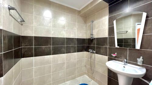a bathroom with a sink and a mirror and a shower at Bratanov Royal Palm Apartments in Sveti Vlas
