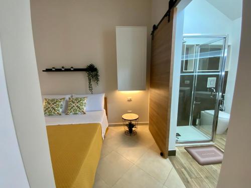 Cette petite chambre comprend un lit et une porte en verre. dans l'établissement “Bedda Mattri” dimora siciliana, à Avola