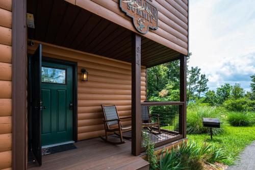um alpendre frontal de uma casa com uma porta verde em Twinflower Summit - Incredible views, pet friendly! em Gatlinburg