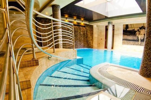 einem Pool mit einer Wendeltreppe in einem Gebäude in der Unterkunft Hotel&Spa Stary Dziwnów basen swimming pool in Dziwnów