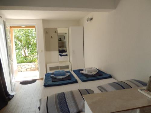 1 dormitorio con 2 camas con alfombras azules en New studio app for 2 en Babino Polje