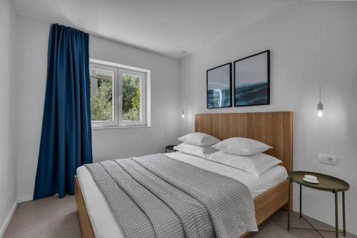 a bedroom with a large bed with a blue curtain at Apartments No 18 in Tučepi