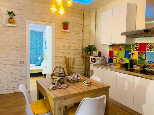 a kitchen with a wooden table and chairs in a room at Suite i biddizzi da Sicilia in Catania