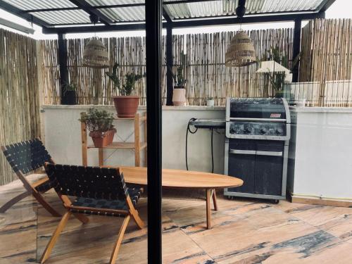 a patio with a table and chairs and an oven at Zoe Rooftop in Netanya