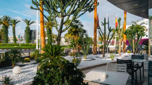 a courtyard with tables and chairs and palm trees at MIRANDA HOTEL - Tanger in Tangier