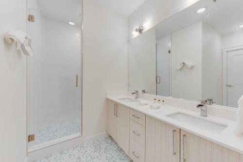een witte badkamer met 2 wastafels en een douche bij Splendid Condo, Stunning Views, 3BD, 2BA, Sleeps 8, Water View in Port Aransas