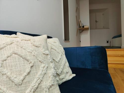 a white blanket sitting on a blue couch at Blue Essence Apartment - Central in Coimbra