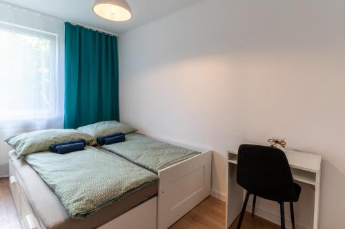 a bedroom with a bed with a desk and a chair at SKY Apartment 2 in Oświęcim