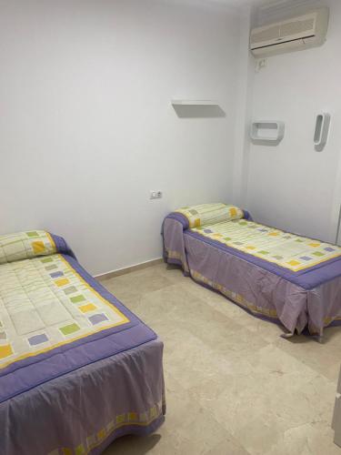 two beds are in a room withthritisthritisthritisthritisthritisthritisthritisthritisthritis at Casa hasta 6 personas in Carraca
