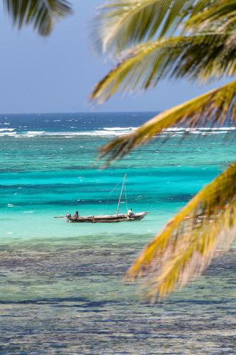a boat in the water on the beach at TASNEEM islamic luxury suites in Jambiani