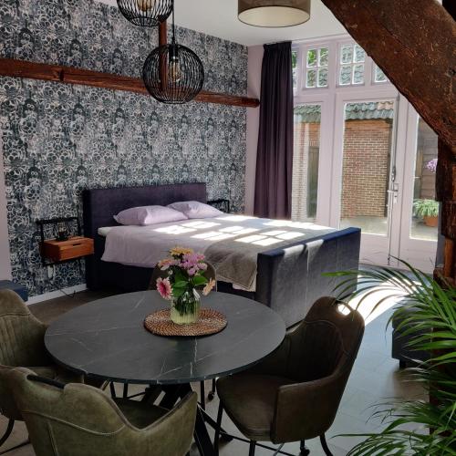 ein Schlafzimmer mit einem Bett und einem Tisch mit Blumen darauf in der Unterkunft B & B Diever in Diever