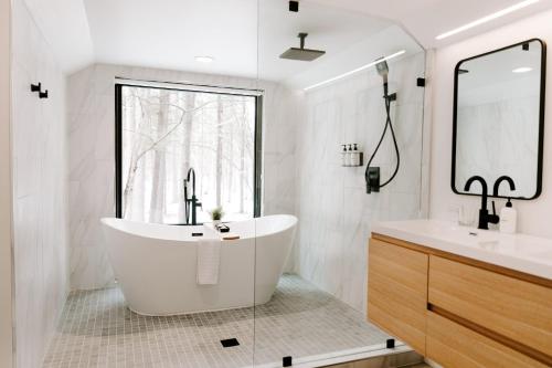 a white bathroom with a tub and a window at Nature Link Resorts in Nisswa