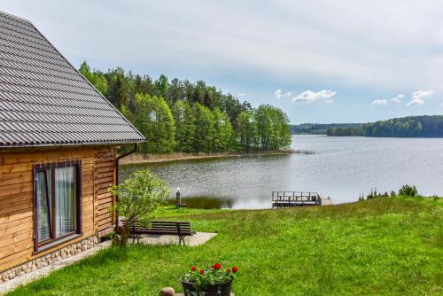 um chalé de madeira com vista para um lago em Nijolės sodyba em Aukstadvaris