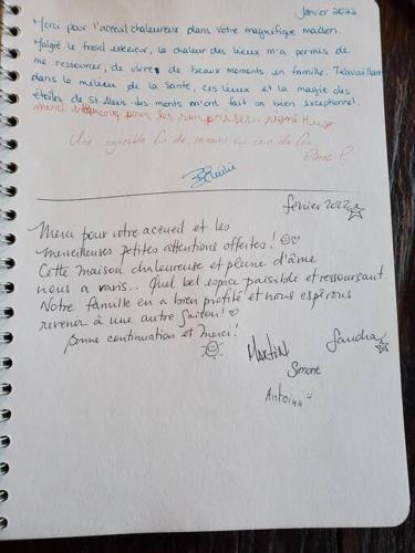 a notebook with handwriting on it on a table at Chalet NABU L'Ours - Rivière - Billard in Saint-Alexis-des-Monts