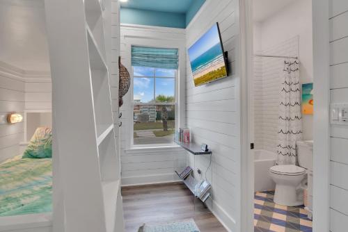 a bathroom with a toilet and a window at Luxury home with great resort amenities in Port Aransas