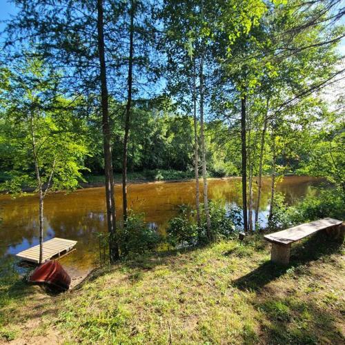 a bench and a table next to a river at Chalet NABU L'Ours - Rivière - Billard in Saint-Alexis-des-Monts
