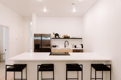 a kitchen with a white counter with black bar stools at Nature Link Resorts in Nisswa
