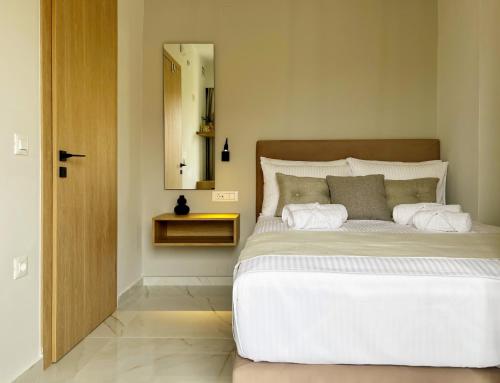 a bedroom with a large white bed and a mirror at B&K ROOMS in Heraklio Town
