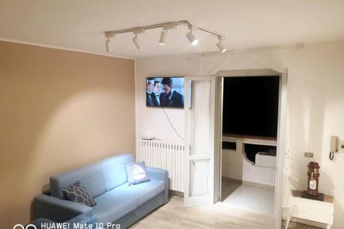 een woonkamer met een blauwe bank en een tv bij Attico con terrazzo Gallipoli in Galatina
