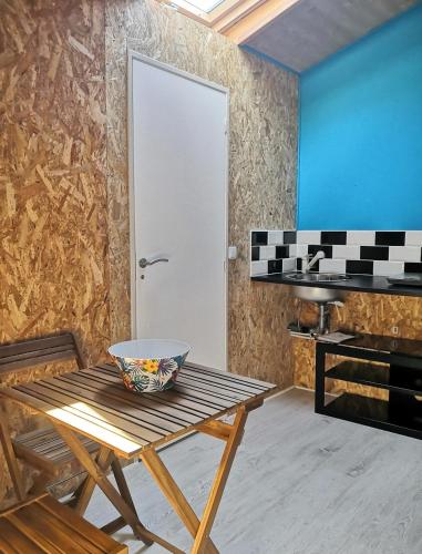 un bol sur une table dans une pièce avec un piano dans l'établissement Entre terre et mer, à Sainte-Eulalie-en-Born