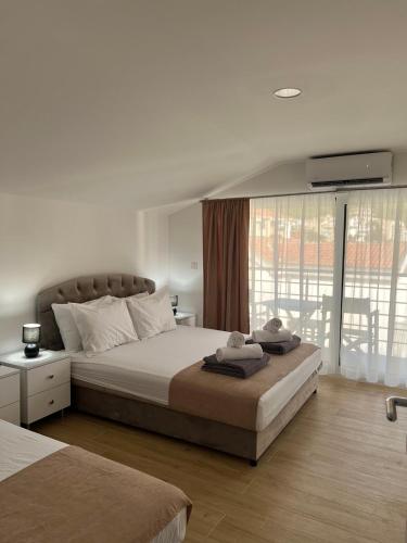 a bedroom with a large bed and a balcony at Gargovic Apartments in Budva