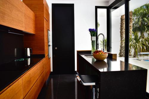 uma cozinha com um balcão preto e armários de madeira em Luxury Villa LAGUNA - Ciudad Quesada em Ciudad Quesada