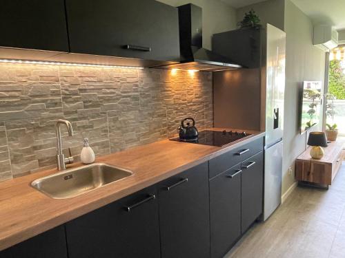 une cuisine avec un évier et un plan de travail en bois dans l'établissement 4-Star Beachfront Appartment- Sea View, à Cannes